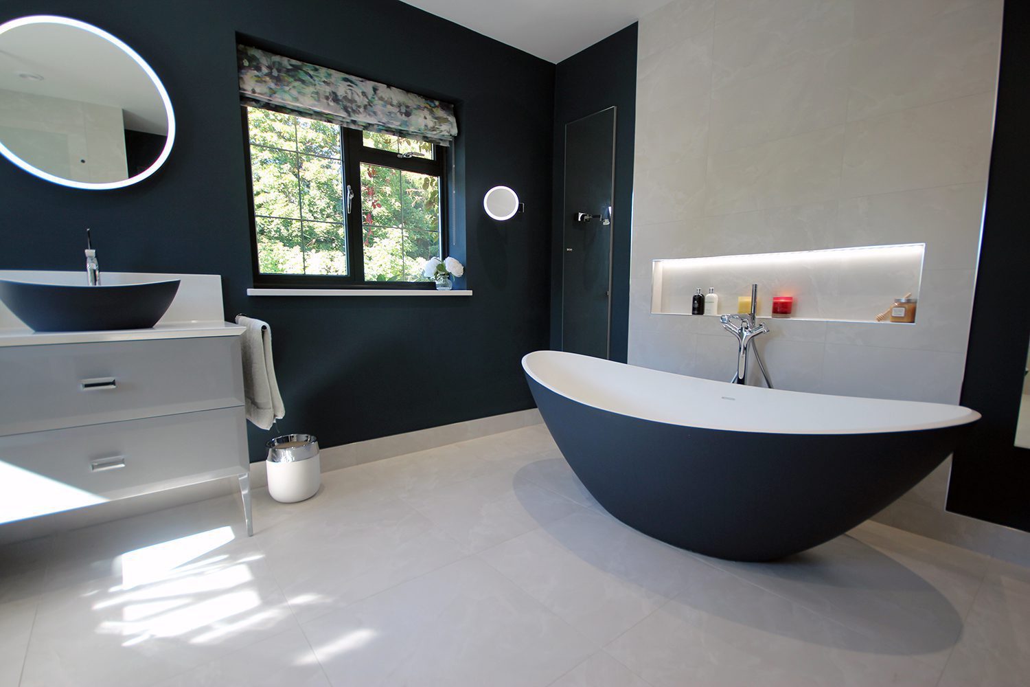 7. Either side of the bath is a bespoke recessed mirror cabinet.