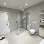 2. A large walk in shower with hansgrohe PowderRain overhead shower and baton handshower.