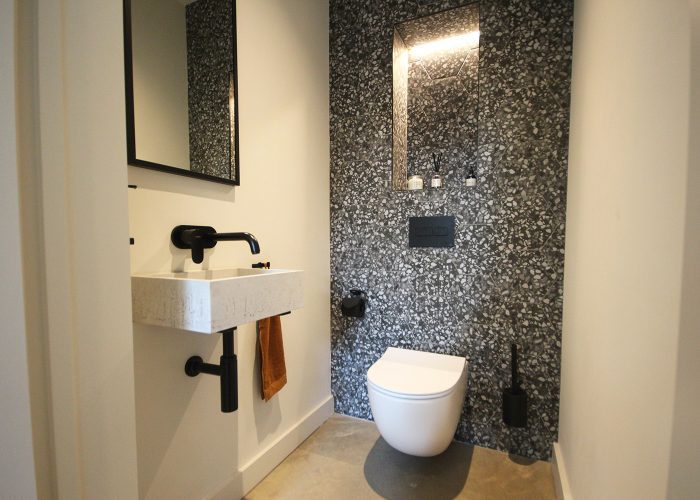 This striking cloakroom with punchy feature tiles is perfect for guests to use.