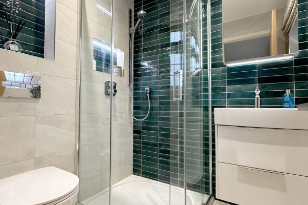 Spacious en-suite with punchy blue feature tiles. Tiled in Minoli 'Cashmere White' and 'Luminious Blue'. Merlyn quadrant shower enclosure.